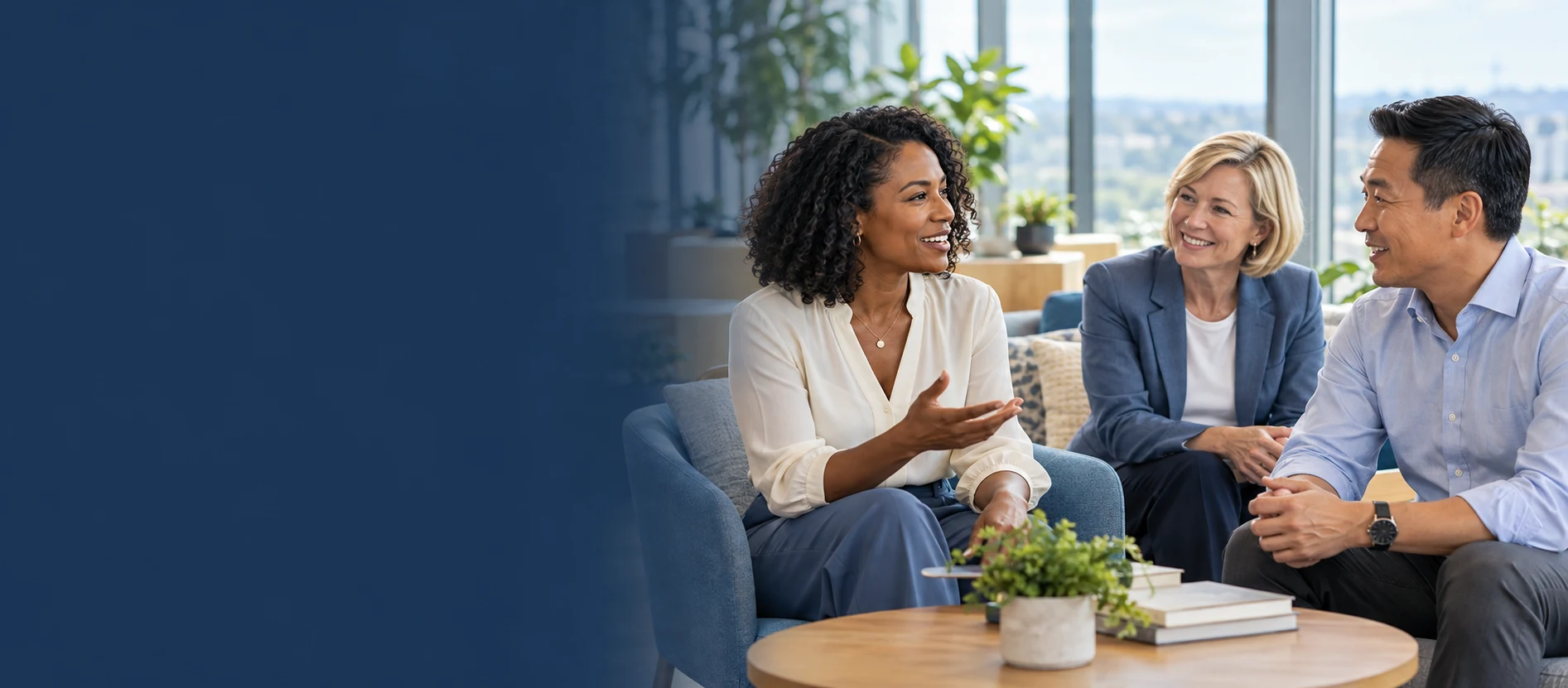 Three colleagues talking in a bright office lounge